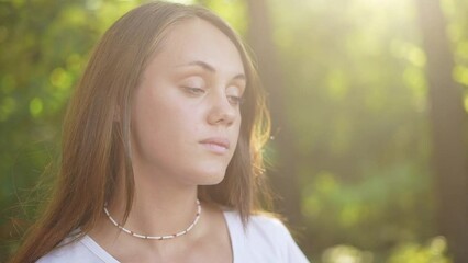 Wall Mural - people in the park. beautiful girl smiling a portrait outdoors in the park. happy family young girl teenager concept. close-up girl teenager the glare of the sun in the forest dream