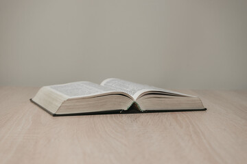 Aufkleber - Open holy bible on a  wooden table. Beautiful white wall background.