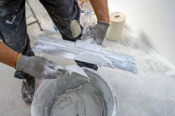 Wall Mural - Plasterer applies plaster on the wall during repair and restoration work