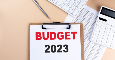 Poster - clipboard with white blank paper text BUDGET 2023 , keyboard calculator and chart, top view. business concept.