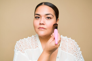 Wall Mural - Close up of attractive fat latin woman using makeup products