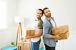 Handsome gay couple holding boxes after moving in together