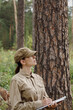 © junky_jess - A woman park ranger in uniform with a clipboard control the forest area in summer, vertical photo, selective focus.