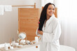 © Prostock-studio - Cheerful Mixed Lady Posing Touching Long Brunette Hair In Bathroom