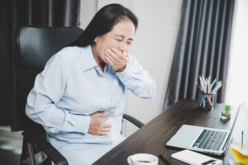 Wall Mural - Young asian business woman person sitting at work and has stress pain in her stomach. Concept office syndrome abdomen pain from occupational disease, Female having belly pain and using laptop computer