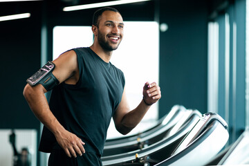 Wall Mural - Happy Handsome Young Black Male Athlete Jogging On Treadmill At Gym