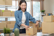 © Pormezz - small business owner packing product order into parcel box at home office. online internet retail.