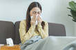 © Pormezz - Sick day at home. Asian woman has runny and common cold.