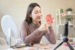 © Pormezz - asian female beauty social media influencer livestream marketing cosmetics a make up tutorial via smartphone.