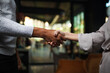© Nikola Spasenoski - Two multiracial business colleagues working after work or during coffee break in a restaurant. Man and woman shaking hands after successful meeting..
