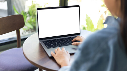 Wall Mural - mock up empty screen notebook, businesswoman working on his laptop computer with blank space screen for advertising text on wood desk in Cafe