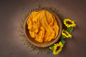 Wall Mural - bowl made of wood, painted with sunflowers. basket for a photo session of a newborn. yellow sunflower flower. heart