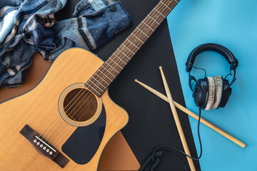 Wall Mural - Music background with guitar and drumsticks, top view.