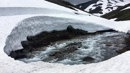 Wall Mural - Mountain rapid river flowing under the caps of snow and ice, the Khibiny mountains in north of Russia