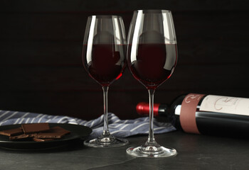 Canvas Print - Glasses and bottle of red wine with chocolate on grey table