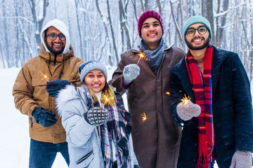 Image of a happy young friends with sparklers at Christmas party