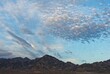 Illuminated altocumulus clouds at sunset over badlands in Death Valley National Park