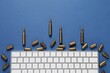 Bullets and computer keyboard on blue background, flat lay. Hybrid warfare concept