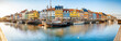 Leinwandbild Motiv Panorama view of Nyhawn, the colorful houses next to the old port. Tourist visiting restaurants, cafes and ships in the canal at dusk. The most important sightseeing spot in Copenhagen, Denmark.