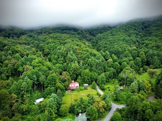 Clouds hanging low over hills with built vacation cabins in Smoky Mountains near the city of Waynesville, NC