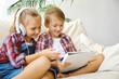 © Inna Vlasova - Cute kids with headphones enjoying tablet at home.