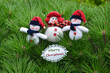 © Mariana - Tree little cute snowman in red hats  and Merry Christmas greeting card  on pine tree background. Christmas greeting concept.
