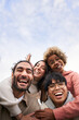 © CarlosBarquero - Vertical pic of Group of young people looking at the camera outdoors. Happy smiling friends hugging. Concept of community and youth lifestyle