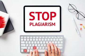 Stop plagiarism concept. Female hands on keyboard with lighted keys control c, digital tablet with sign STOP PLAGIARISM on screen.