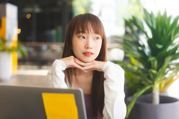 Wall Mural - Portrait of young adult asian student woman using laptop at cafe for study and work