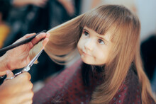 
Cute Toddler Girl Getting Her Hair Cute In A Professional Salon. Little Preschool Child Having A Haircut In A Beauty Studio
