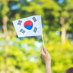 Wall Mural - hand holding Korea flag on nature background. National Foundation, Gaecheonjeol, public Nation holiday, National Liberation Day of Korea and happy celebration concepts