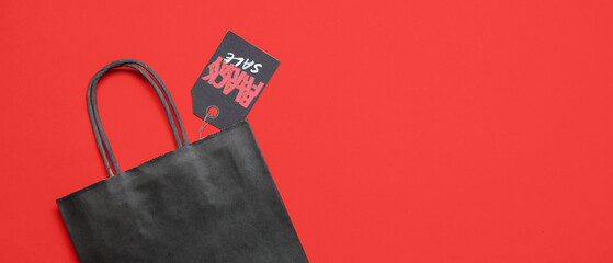 Sticker - Shopping bag and tag with text BLACK FRIDAY SALE on red background with space for text