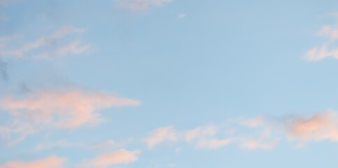 Wall Mural - Blue sky background with pale pink clouds at sunset