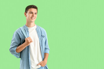 Canvas Print - Teenage boy with backpack on green background