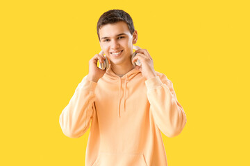 Poster - Teenage boy with headphones on yellow background