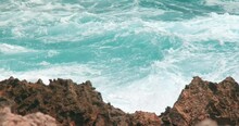 Ocean Waves Swelling And Crashing Onto The Rocky Shore In Caribbe