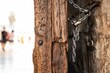 Closeup shot of an old wooden door and rusted lock chain detail