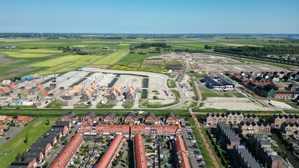 Canvas Print - Drone shot of the Assendelft town with houses and streets in The Netherlands under blue sky