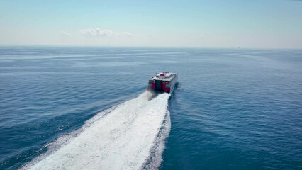 Wall Mural - aerial view of a catamaran jet passenger ferry traveling with speed over blue ocean