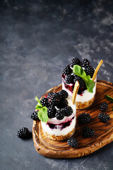 Wall Mural - Blackberry granola yogurt dessert with berris and mint leaf on wooden cut borad