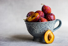 Close-Up Of Organic Red Ripe Plums In A Bowl