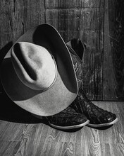 Vertical Closeup Of Boots And An Old-fashioned Hat Shot In Grayscale
