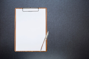 Wall Mural - Paper clipboard with blank white paper and new pen on black fabric texture background, education and business object