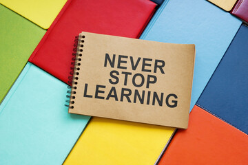 Wall Mural - Never stop learning sign on the colorful books.