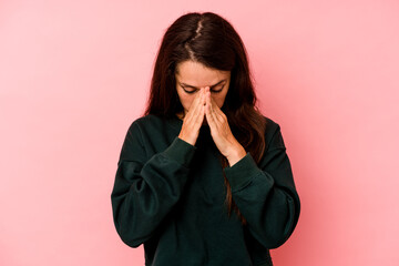 Young caucasian woman isolated on pink background praying, showing devotion, religious person looking for divine inspiration.