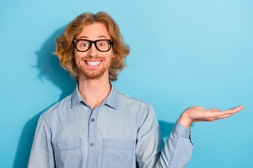 Poster - Photo of funky sweet man wear denim shirt spectacles holding arm empty space isolated blue color background