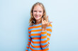 Caucasian teen girl isolated on blue background showing rock gesture with fingers