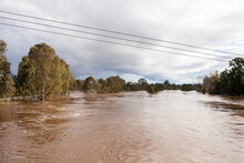 Wide Brown River Full Of Floodwater During Natural Disaster Flood