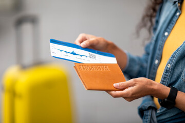 Wall Mural - Unrecognizable woman in casual outfit holding passport and flight tickets