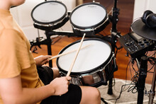 Teen Boy Practising Drums At Home